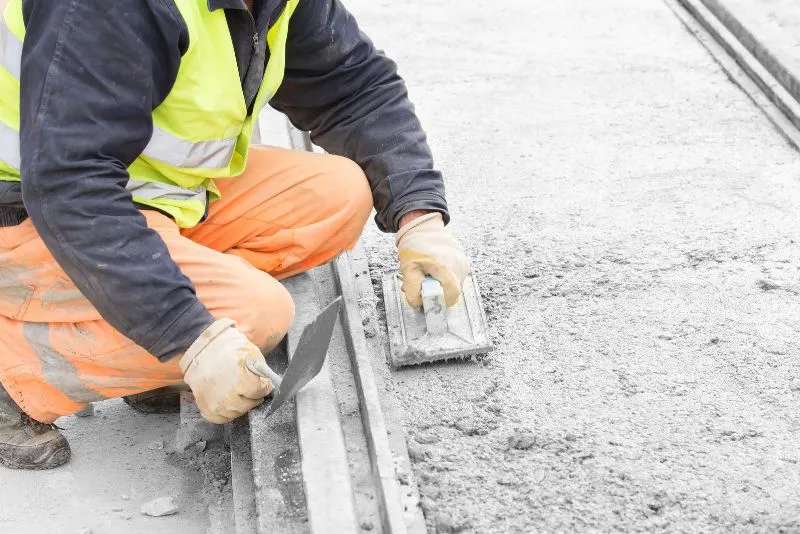 Concreter hand-finishing the edge of a fresh concrete pour