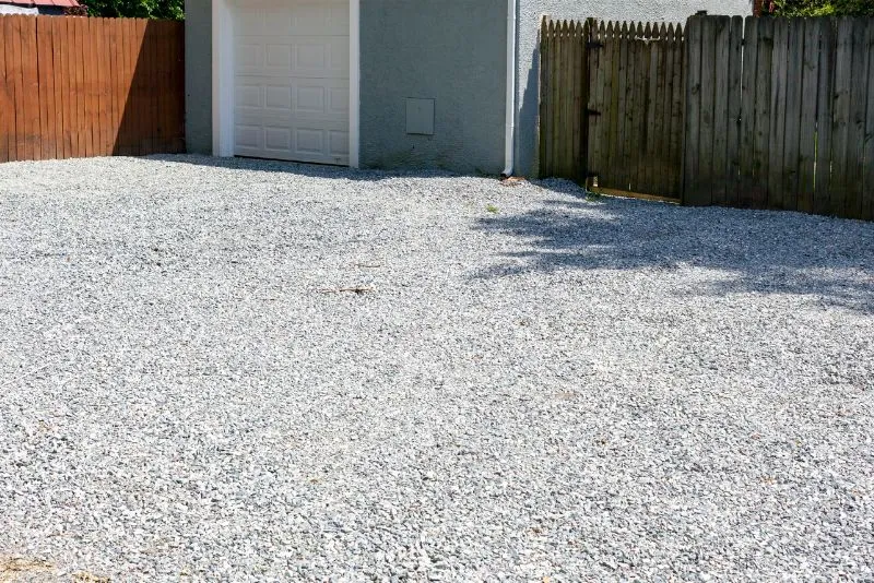 Gravel base being prepared ahead of a concrete driveway pour