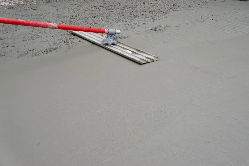 Concrete slab being levelled with a screed tool