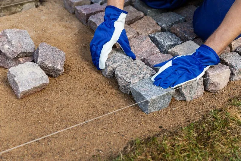 Stone pavers being installed to form a paved outdoor pathway