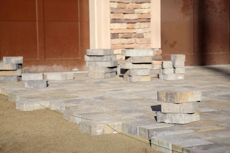 Concrete pavers being installed to form an outdoor paved surface