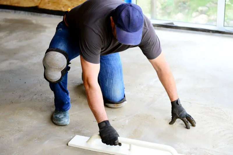 concreter polishing concrete floor with a trowel