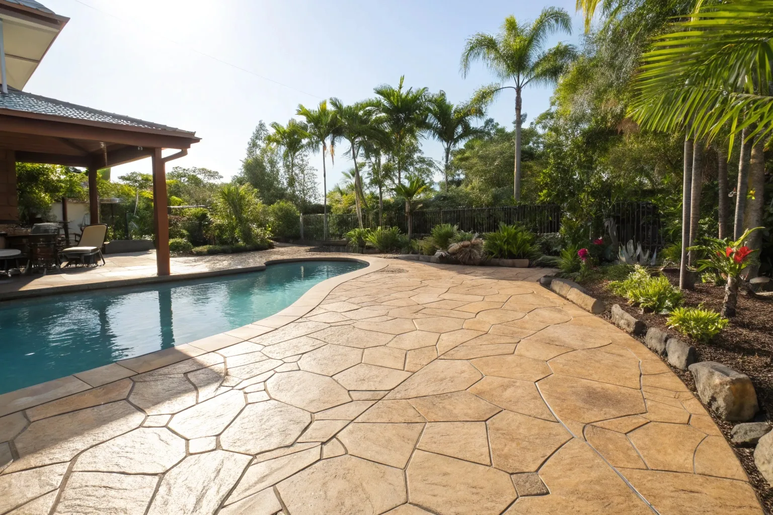 Stamped concrete pool surround with flagstone pattern in Gold Coast backyard